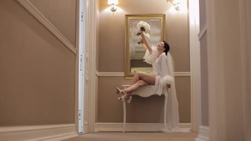 Lovely Stylish Bride Girl in Sunglasses Holding Bouquet Smiling Sitting Indoors at Hotel Corridor