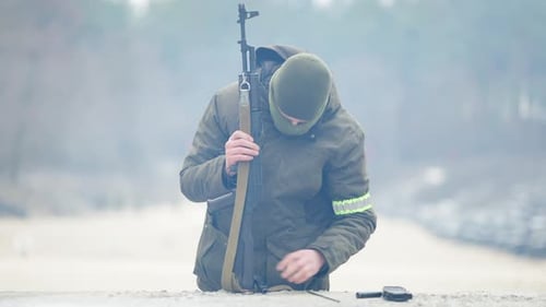 Portrait d'une recrue sérieuse et déterminée démontant des armes militaires à l'extérieur