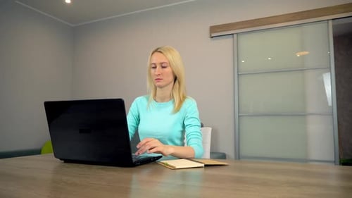 A woman is trained through an online course sitting at home.