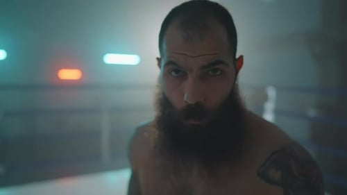 Intense Bearded Man Stares in Boxing Ring