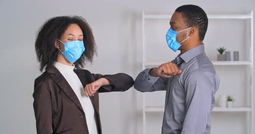 Man and Woman Elbow Bump Wearing Face Masks
