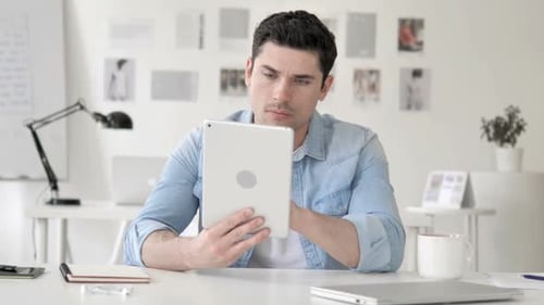 Casual Young Man Using Tablet in Office