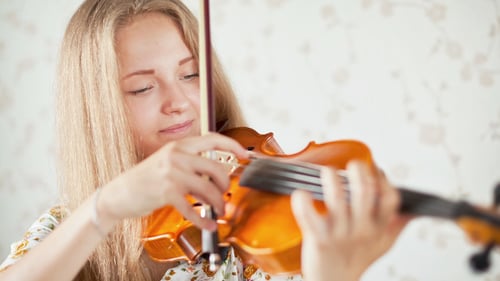 Blonde Woman Plays Violin at Home