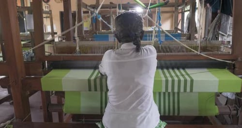 A Footage of a Woman Using Loom in a Traditional Asaian Factory