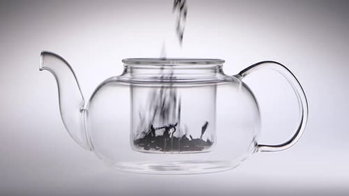Loose Leaf Tea Being Poured into a Teapot