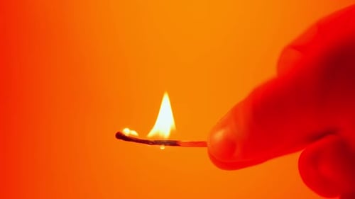 Burning Match Held in Fingers Close Up