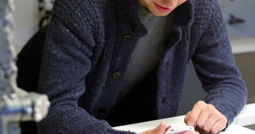 Young Adult Using Smartphone and Tablet Indoors