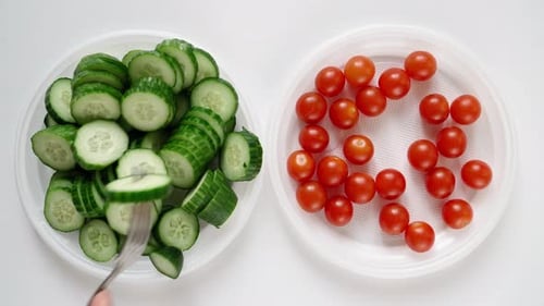 Un homme au régime mange des tomates au chili et du concombre dans une assiette