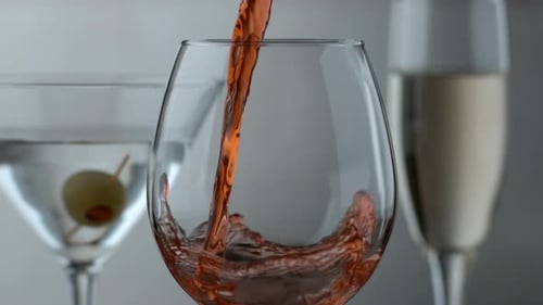 Servir uma taça de vinho tinto com outras bebidas ao fundo; filmado no Phantom Flex 4K a 1000 fps