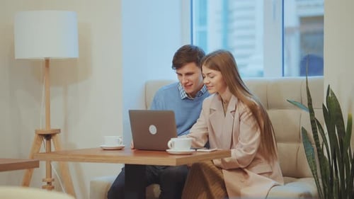 Loving Couple Using Laptop in Cafe