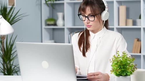 Woman Working at Laptop Wearing Headphones