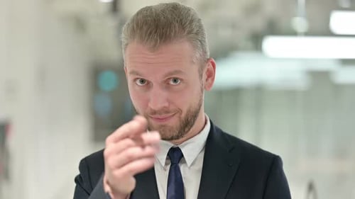 Portrait of Assertive Businessman Pointing with Finger and Inviting