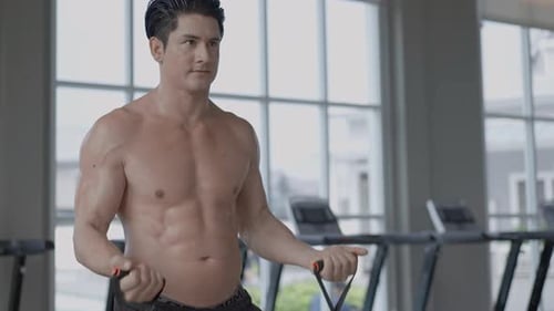 Man Working Out with Resistance Band in Gym