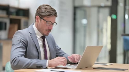 Businessman Working on Laptop in Office