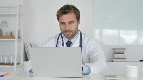 Doctor Using Laptop for Telemedicine in Bright Office