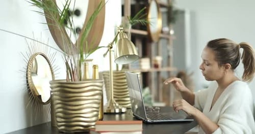 Woman Typing at Desk Removing Glasses Looking Stressed