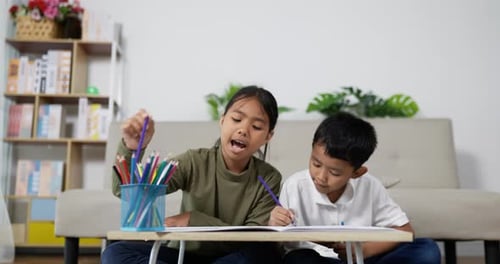 Boy and Girl Drawing Together with Colored Pencils