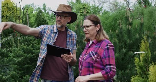 Gardeners Using Tablet in Nursery Garden