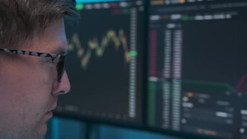 Businessman working at night looking at monitor in eyeglasses. Person stock market trader