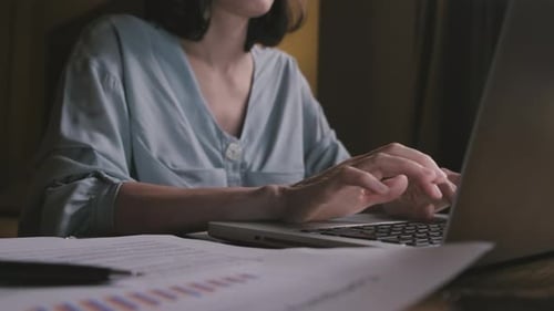 Close up of business woman work overtime in living room at late night due to Covid 19 pandemic.