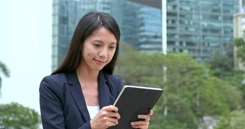 Woman Using Tablet in Front of Modern Building