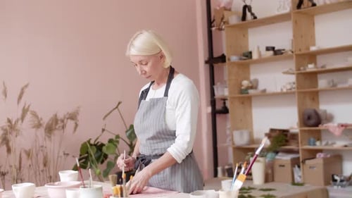 Femme potière fabriquant de la faïence dans un atelier