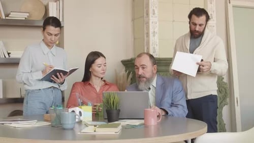 Team of Adults Working at Table in Office