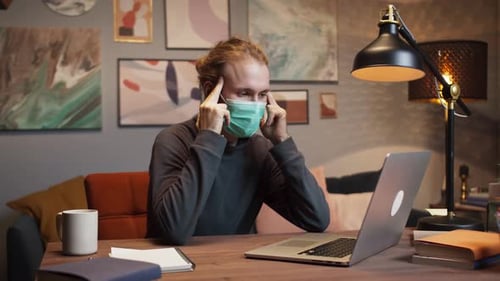 Mixed Race American Freelancer Tired Man Wearing Mask Finishing to Work on Laptop Having Break Doing