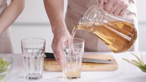 Pouring Refreshing Golden Drink into a Glass