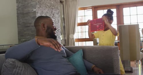 Girl Presents Valentine's Card to Man Indoors