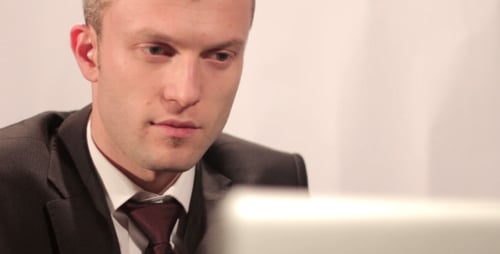 Young Man Working Seriously on Computer at Desk
