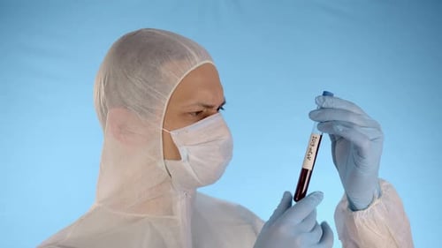 Hombre con traje protector, máscara médica, guantes, sostiene un tubo de ensayo con coronavirus