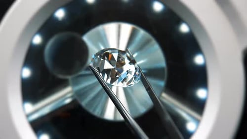 Gem Held in Tweezers Under Bright Light