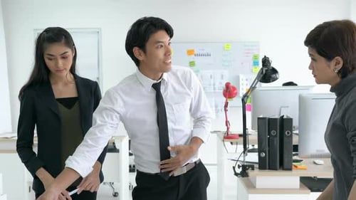 Three Professionals Discussing Plans in Modern Office Space