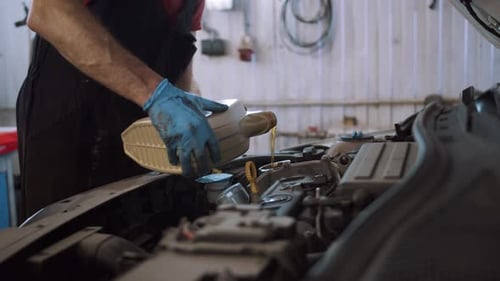 Mechanic Changing Oil in Car Engine