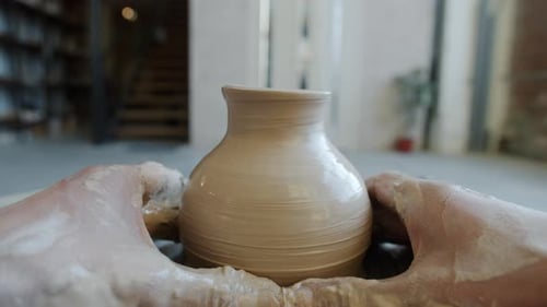 Boucle cinemagraph d'un magnifique vase en argile tournant entre les mains d'un artisan dans un atelier