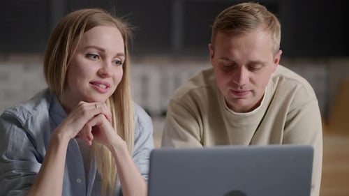 Woman and Man Looking at Laptop Indoors