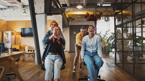 Creative Business Team Having Fun at Work Competing on Chars in Office Corridor