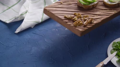 Hands Prepare Avocado Toast on Cutting Board