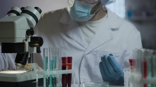 Scientist Analyzing Sample Under Microscope in Laboratory