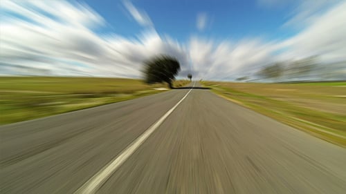 Driving Car on the Road in Green Fields