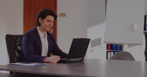 Happy Young Adult Using Laptop in Office