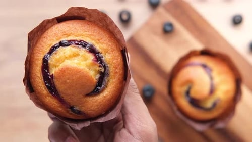 Hand Holding Blueberry Muffin Close Up