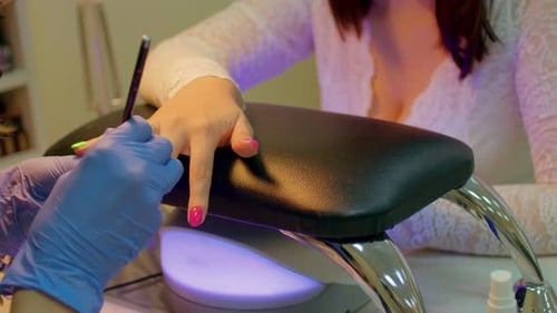 Close Up of Woman Getting Nails Painted Green