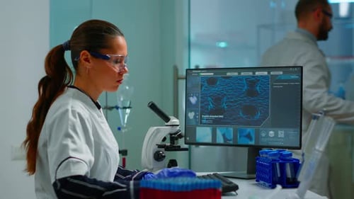 Woman Working With Microscope in a Laboratory