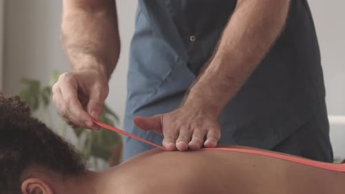 Applying pink bandage to patients back