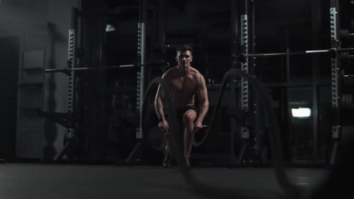 Healthy Lifestyle Athletic Man Performs Exercises with Battle Ropes Endurance Training in the Gym