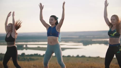 Women Stretching Arms Outdoors in Natural Setting