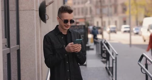 Laughing Man Using Phone in a City