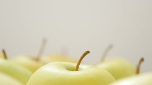 Green organic apples with petals in group close-up 4K 2160p 30fps UltraHD tilting footage - Lot of j